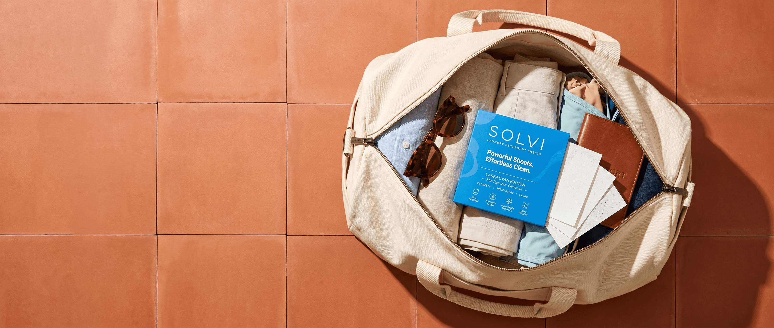SOLVI carton packed in a weekender bag with sheets fanned beside it